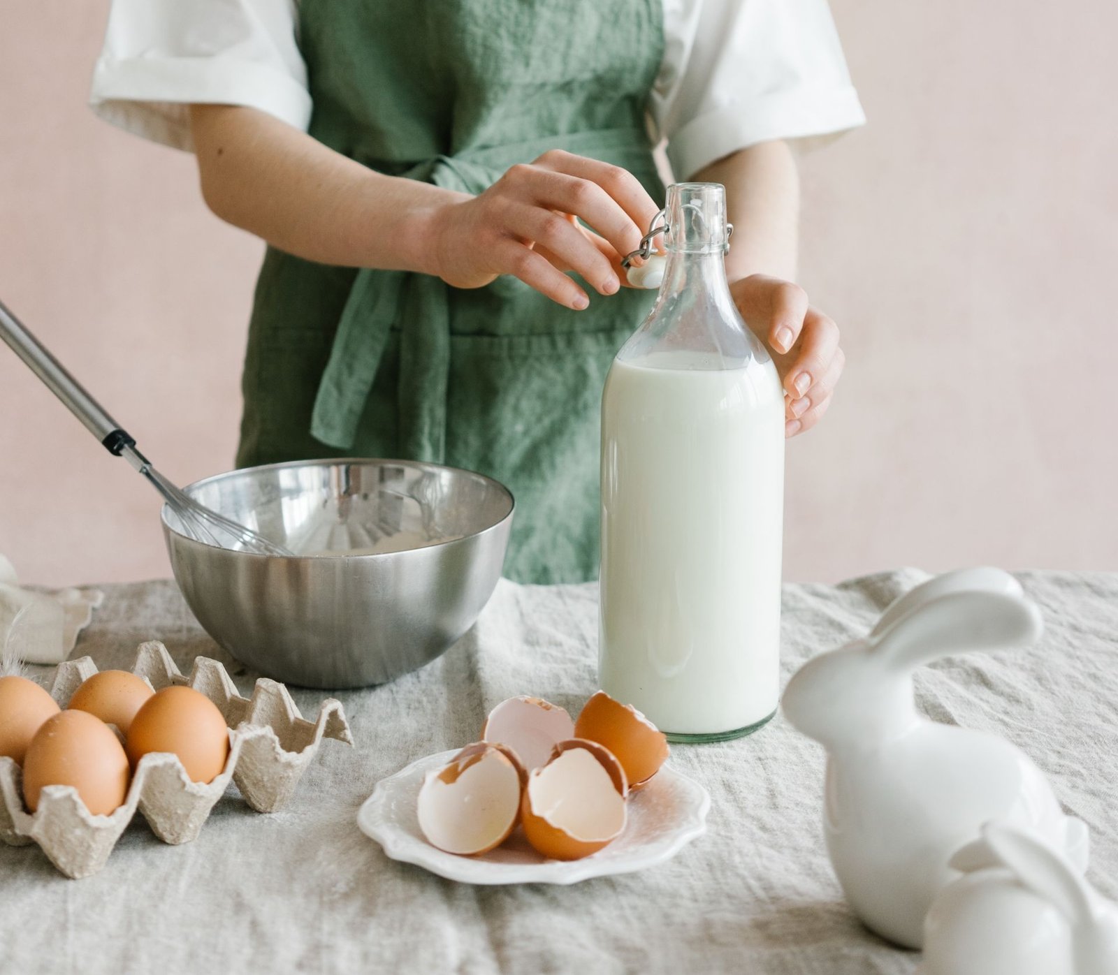 Mujer joven preparando alimentos ricos en vitamina d3, usando huevo y leche