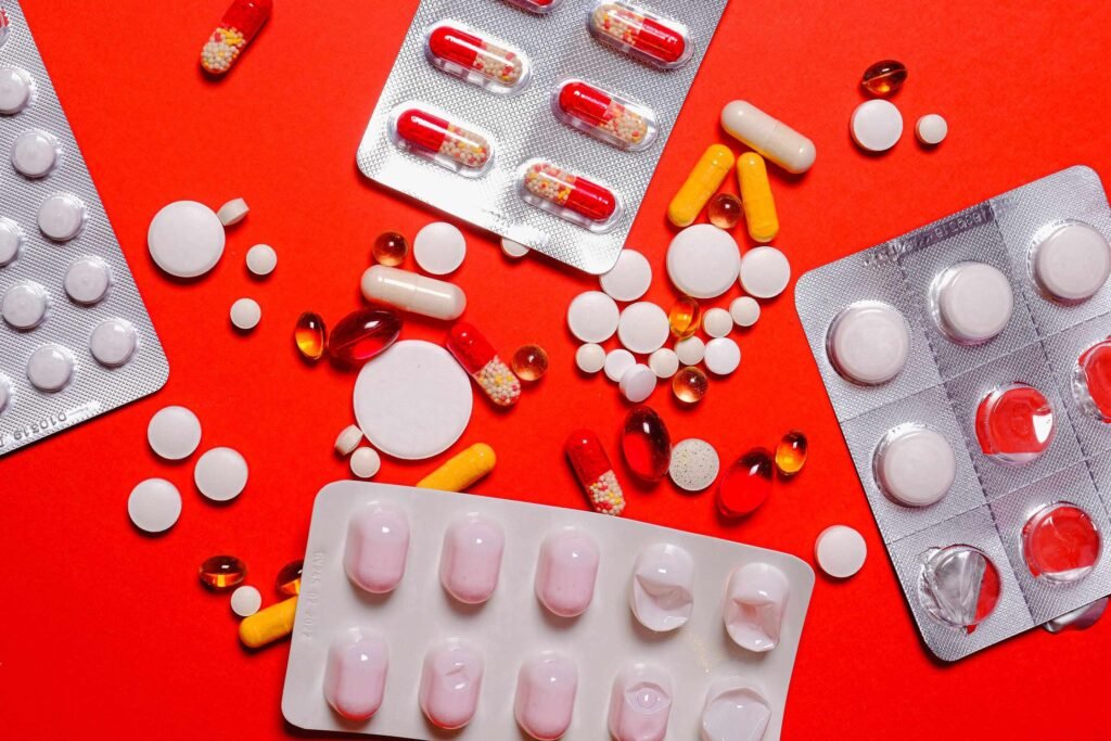 Colección de suplementos y medicamentos sobre un mantel rojo. Enfatiza la importancia de la transparencia en la información y documentación de los suplementos y medicamentos.
